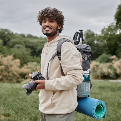 indian-backpacker-smiling-and-holding-digital-came-ZNM4S4V indian-backpacker-smiling-and-holding-digital-came-ZNM4S4V